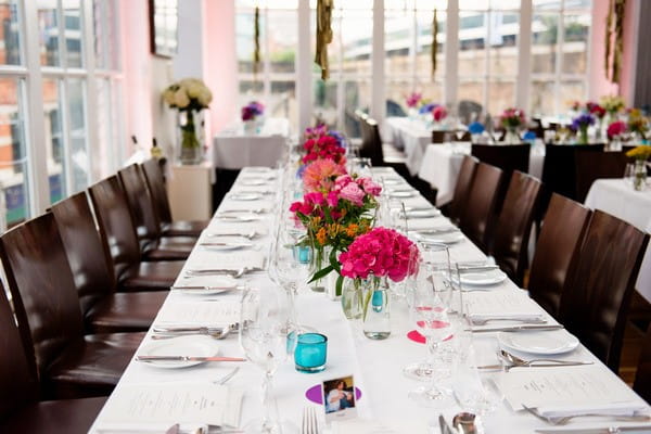 Lond wedding table with colourful wedding table centrepieces