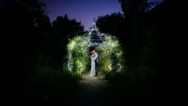 Bride and groom under the Wedding Pavilion at Gaynes Park at night