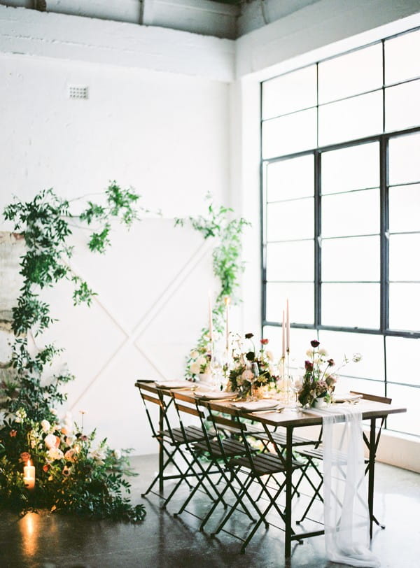 Wedding table and foliage backdrop in urban loft space