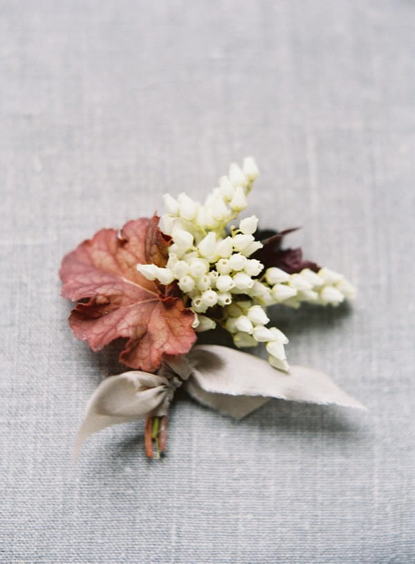 Buttonhole with red leaf and white heather flowers