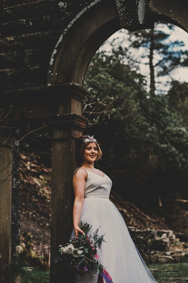 Bride leaning back on pillar