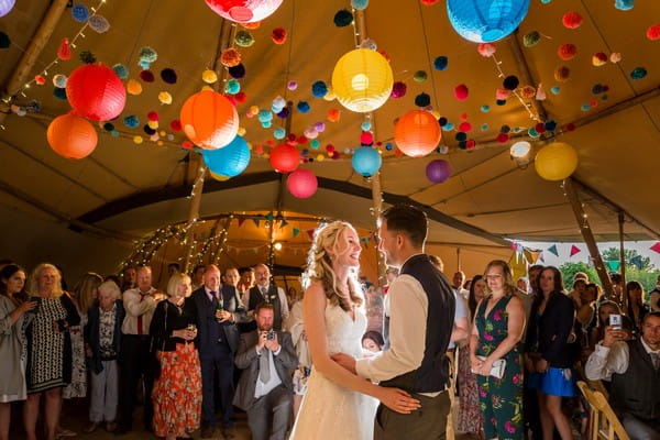 Bride and groom on dance floor under colourful lanterns - Picture by Heather Jackson Photography