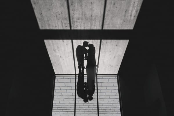 Bride and groom kissing with their shadow showing on floor - Picture by Murray Clarke