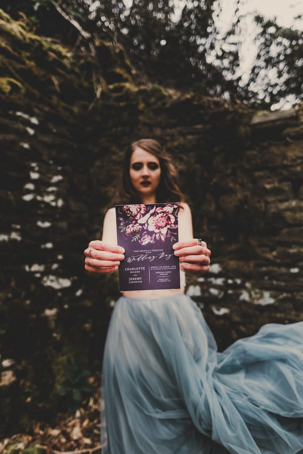 Bride holding ultra violet wedding invitation