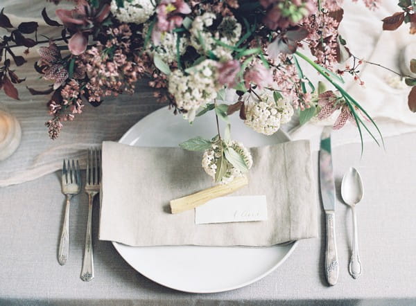 Simple, elegant wedding place setting with light grey napkin