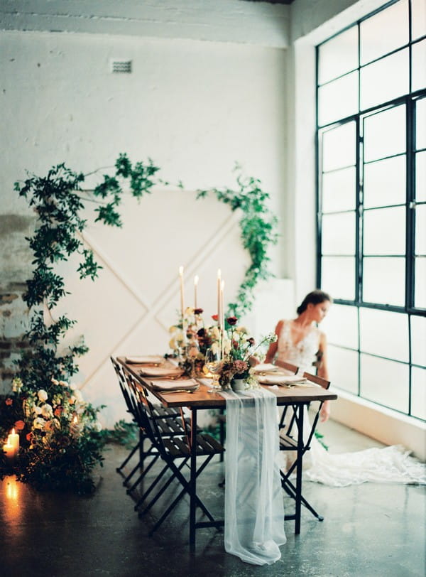 Bride sitting at wedding table in urban loft space