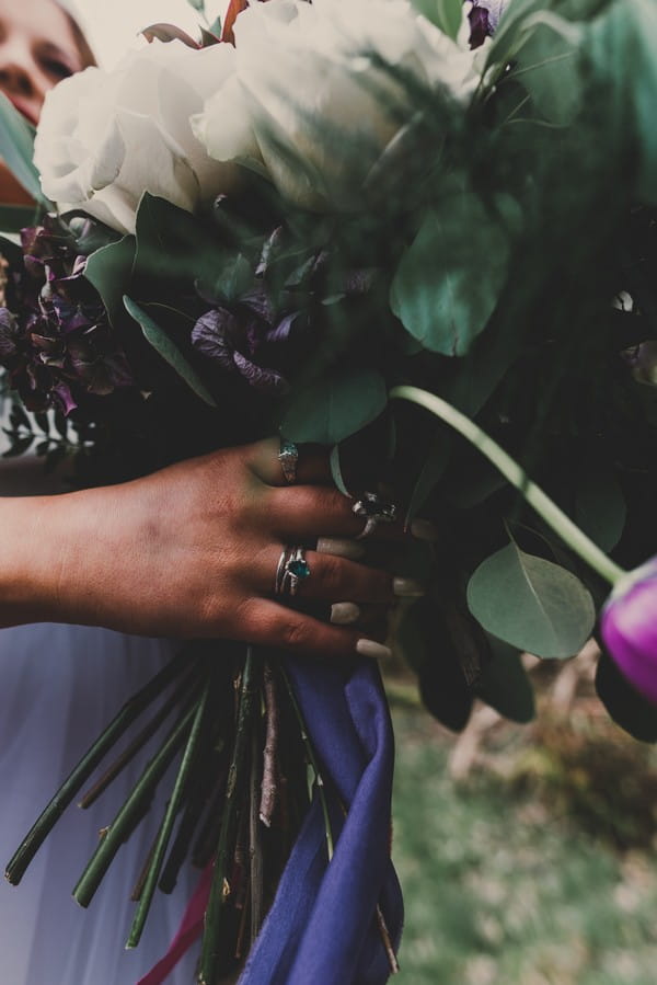 Hand with rings holding wedding bouquet