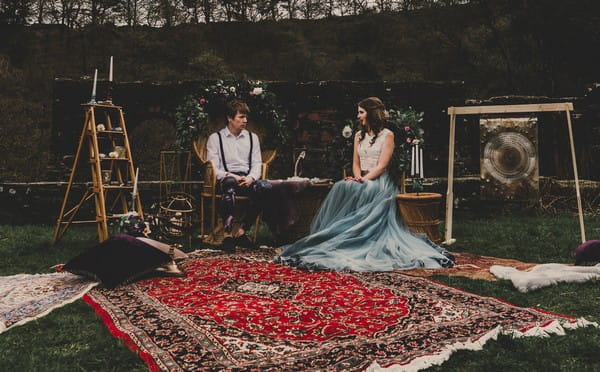 Bride and groom sitting in outdoor seating area with celestial styling