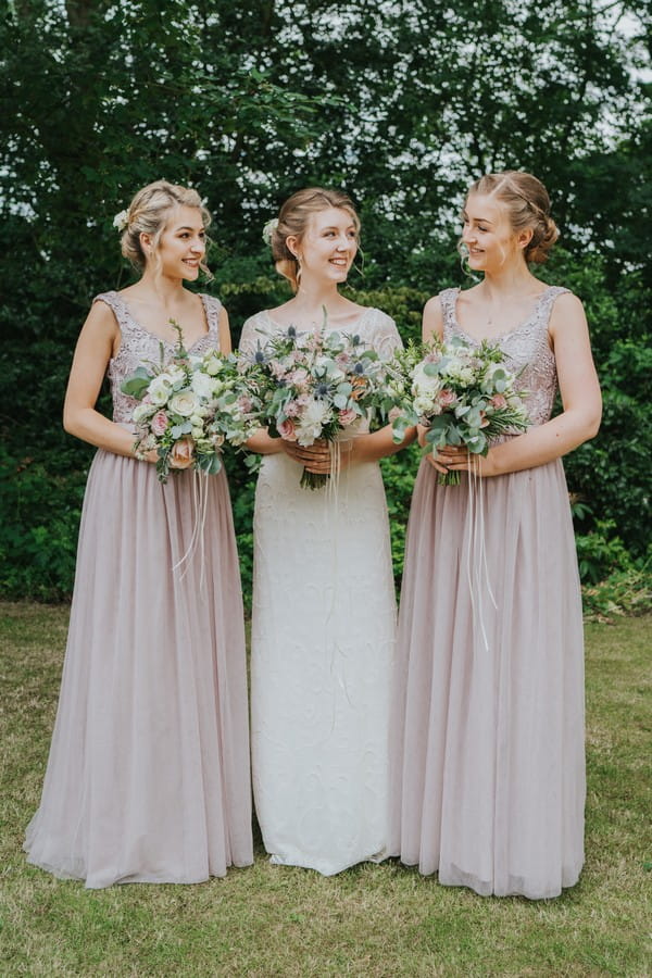 Bride and her two bridesmaids holding bouquets