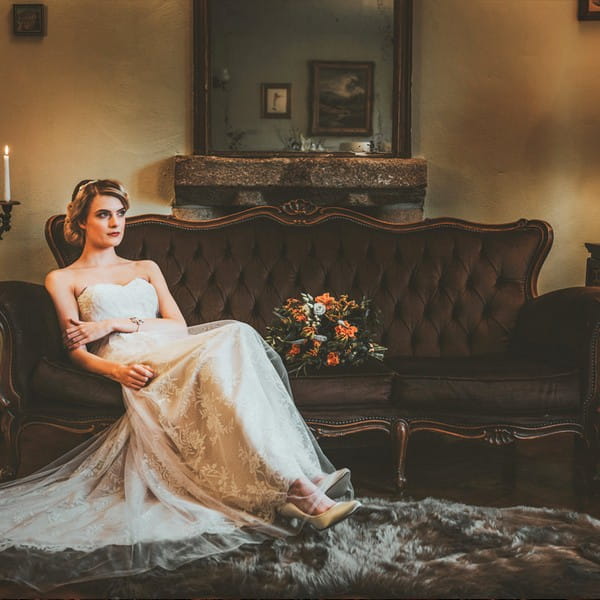 Bride sitting on chocolate coloured sofa available to hire from from The Prop Factory