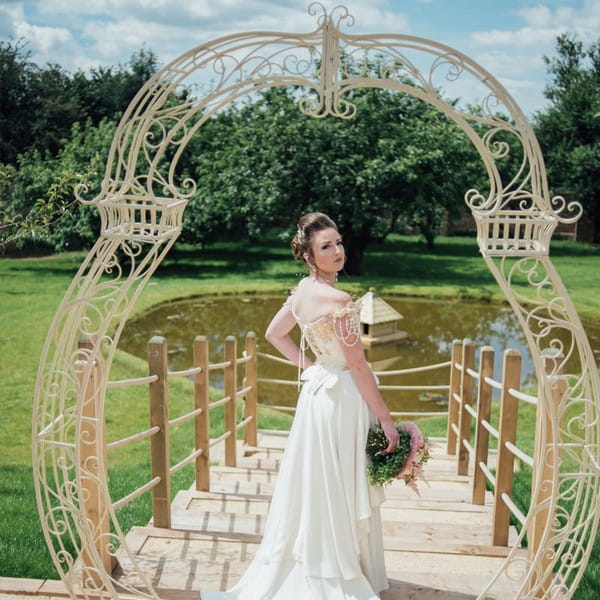 Bride under cream arch available to hire from from The Prop Factory