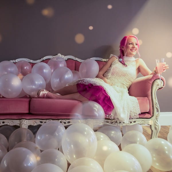 Bride sitting on pink sofa available to hire from from The Prop Factory