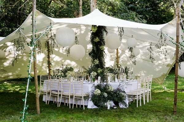 Wedding table styled with greenery under stretch tent in grounds of Cosawes Barton