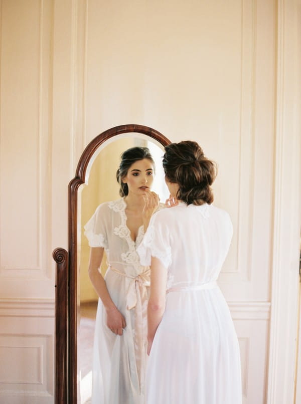 Bride doing make-up in mirror