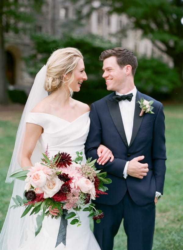 Bride and groom with linked arms smiling at each other