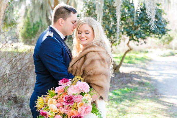 Groom resting head on bride wearing fur shrug