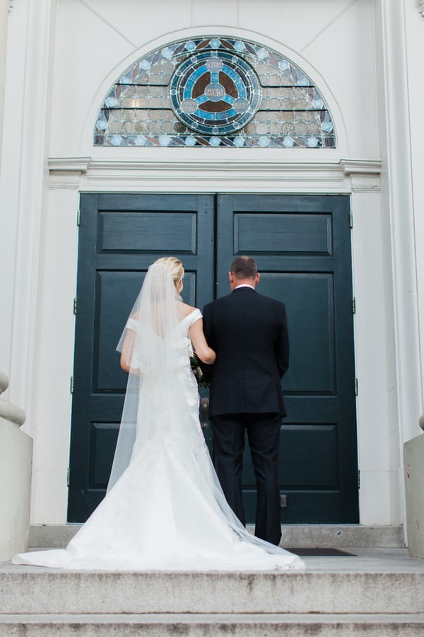 Father and daughter waiting at door to wedding ceremony venue