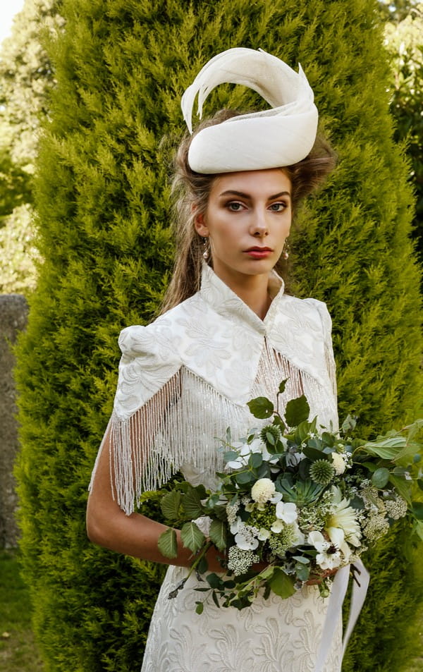 Bride wearing bridal hat holding bouquet