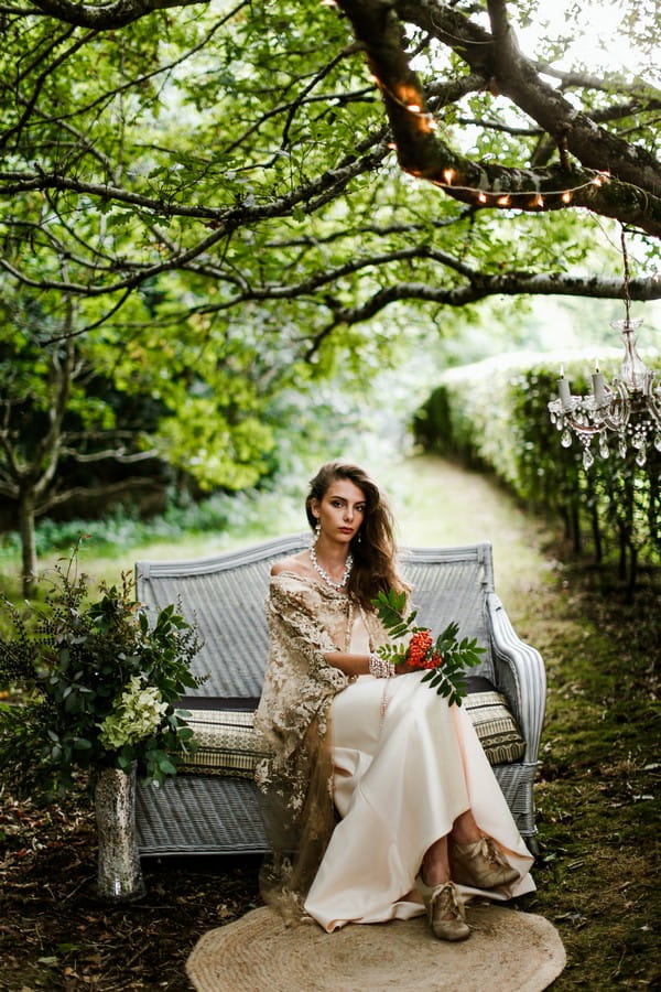 Bride sitting on couch in woodland at Cosawes Barton