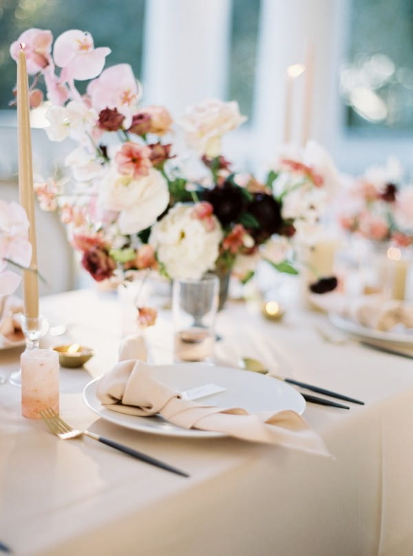 Wedding place setting with blush flowers and tie napkin