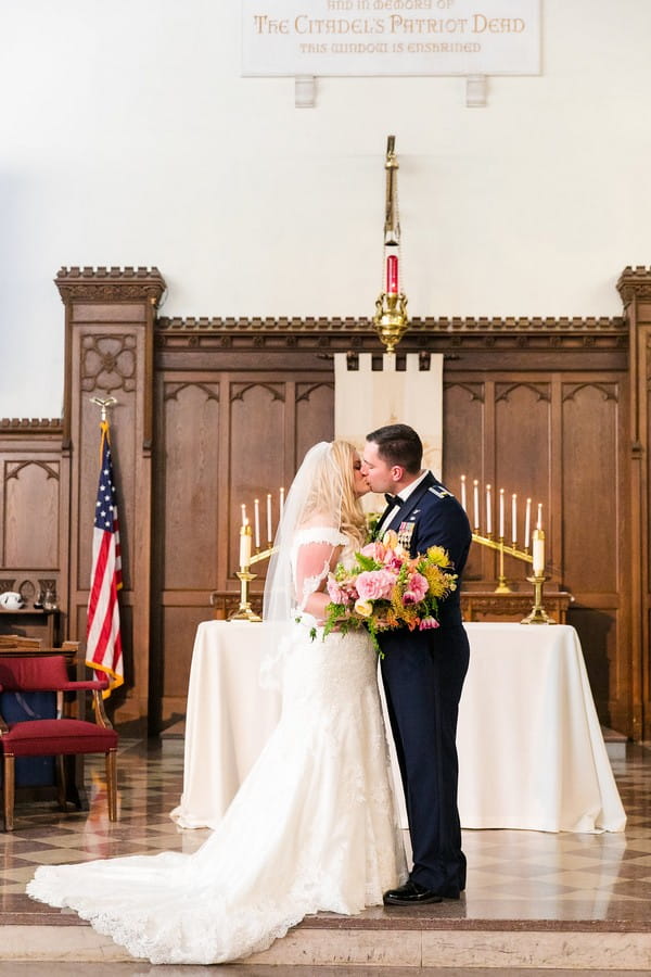 Bride and groom kiss at the altar