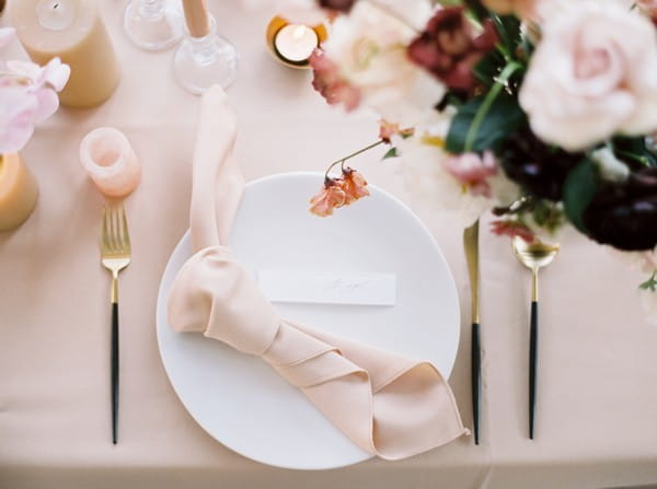 Wedding place setting with tied napkin on plate