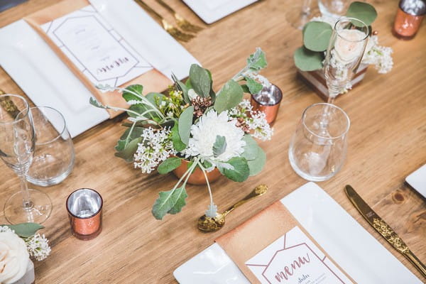 Flowers in copper pot on wooden wedding table