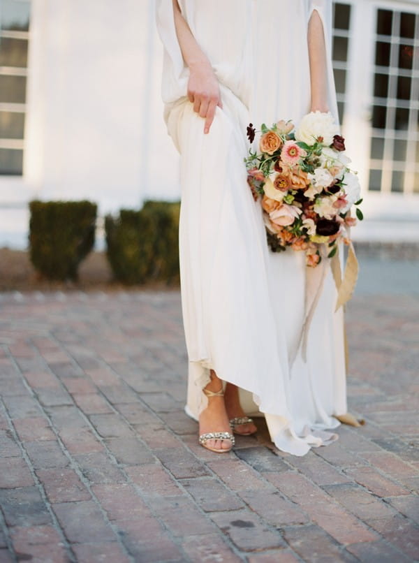 Bride pulling up dress to show shoes