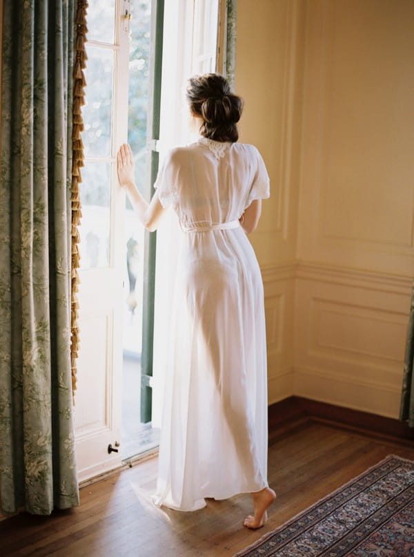 Bride in dressing gown standing by door