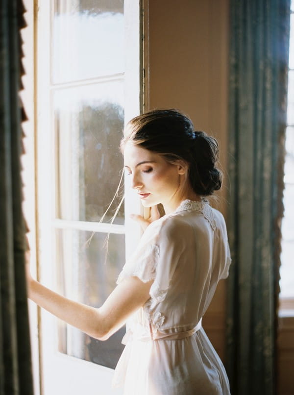 Bride in dressing gown standing in doorway