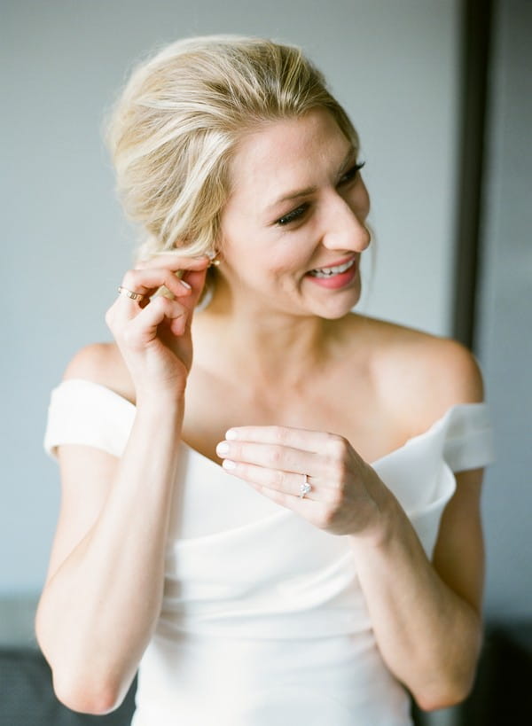 Bride putting on earring