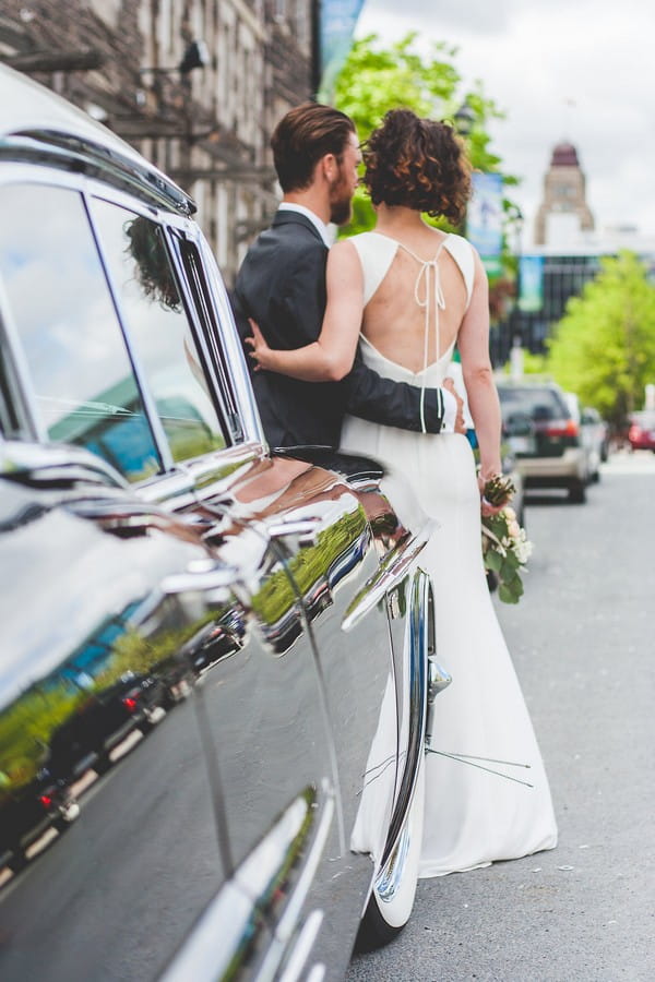 Bride and groom in front of wedding car