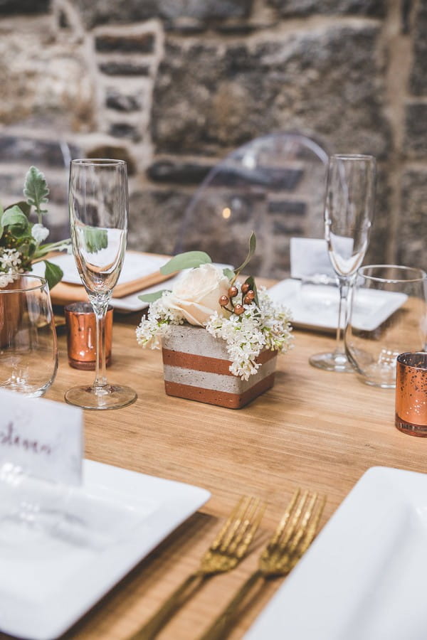 Wedding table flowers in concrete pot with copper stripe