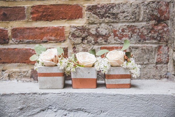 Wedding flowers in concrete pots with copper stripes