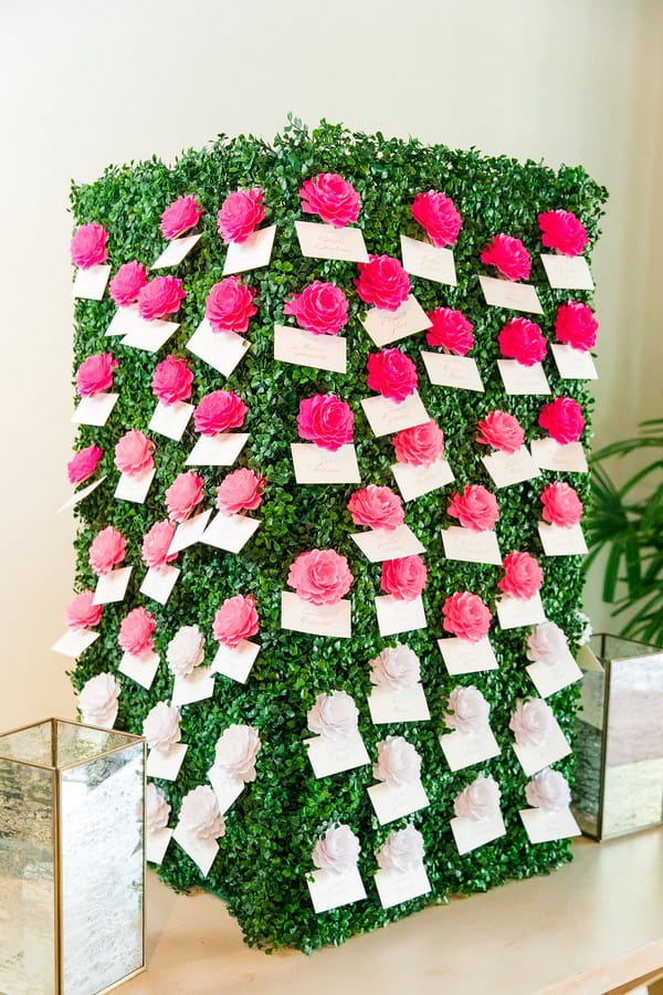 Foliage box with escort cards attached to pink and white flowers