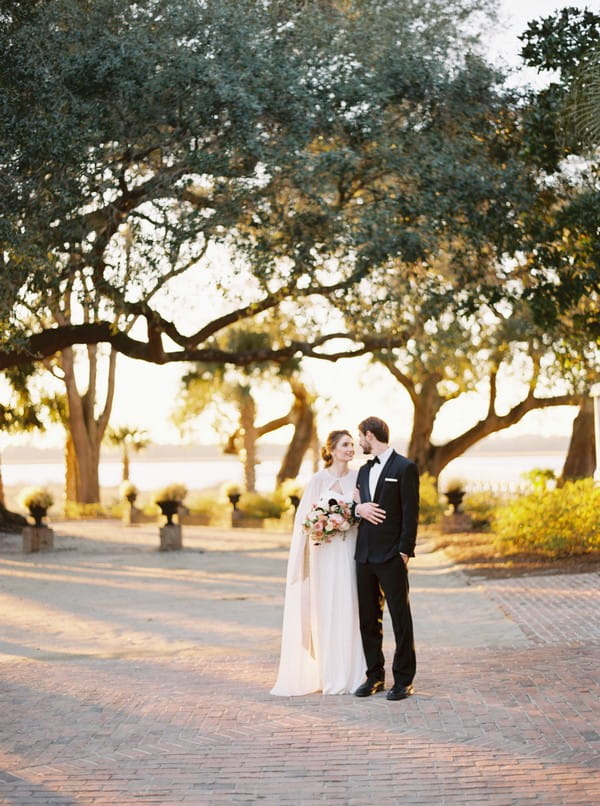 Bride and groom on path in front of trees