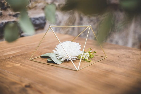 White flower underneath wire geometric decoration