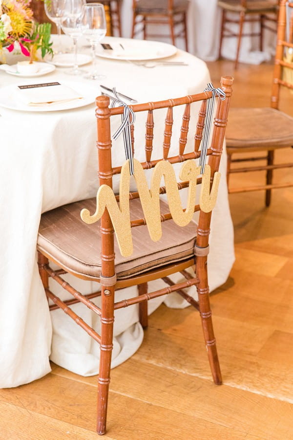 Gold Mr sign hanging from back of wedding chair