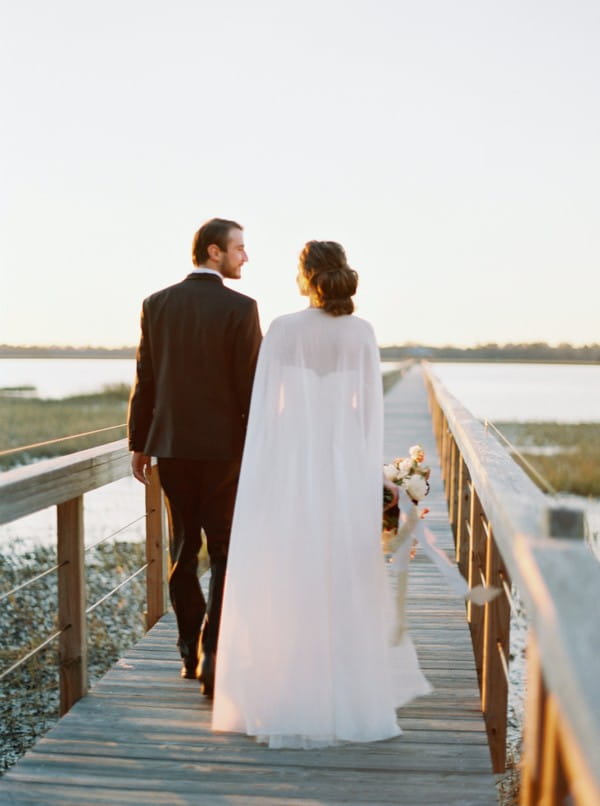 Bride and groom walking over wooden bridge