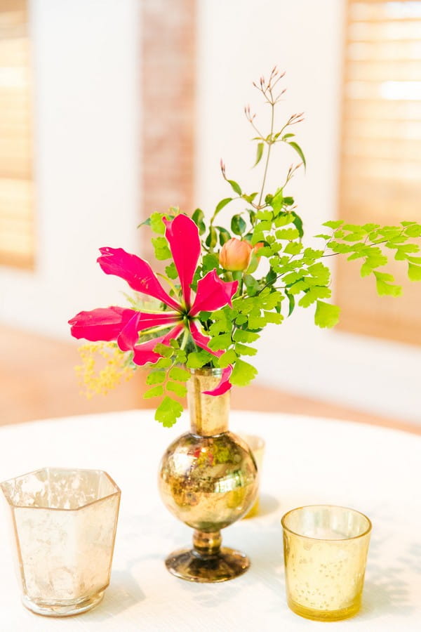 Small gold vase with pink flower and foliage