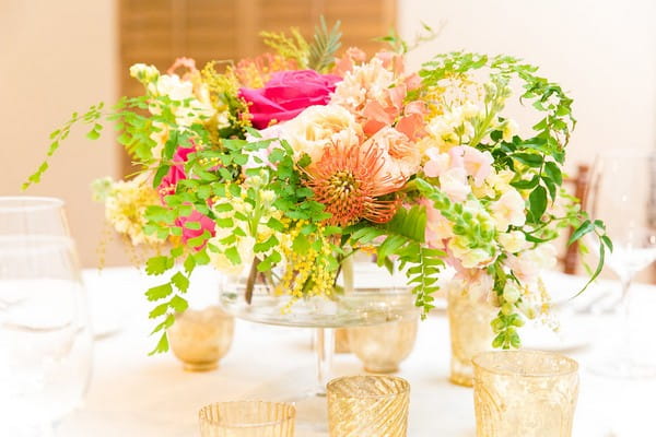 Bright, colourful wedding table flowers with foliage