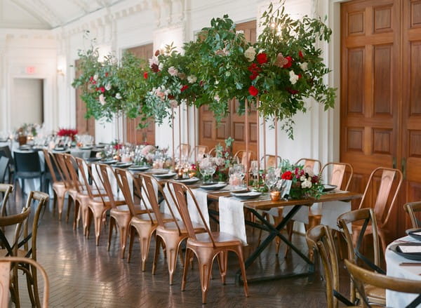 Long wedding table with hanging floral display over top