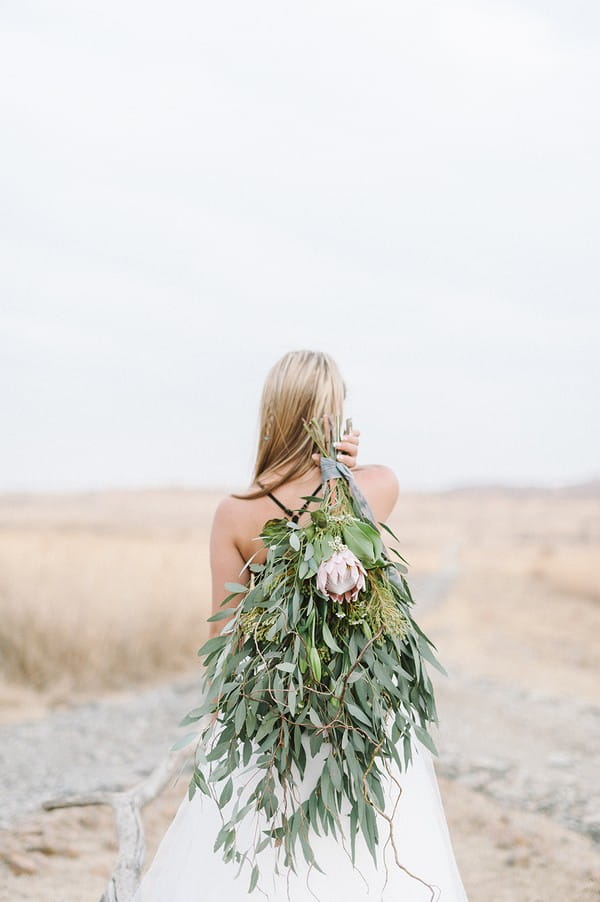Bride with foliage bouquet over her shoulder