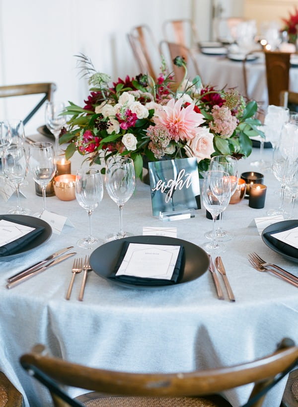 Wedding table with black plates and floral centrepiece