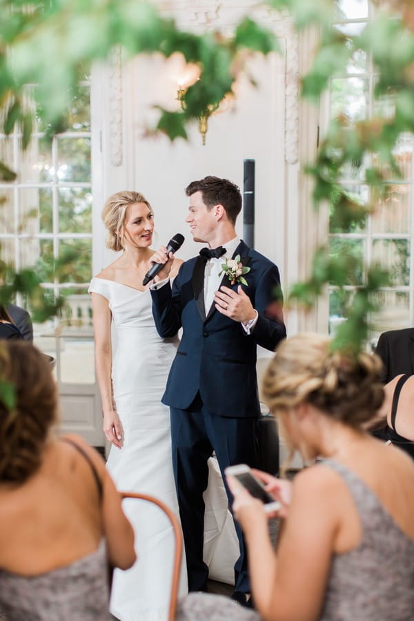 Groom giving speech with bride