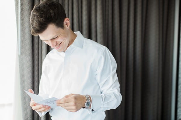 Groom reading note from bride before wedding