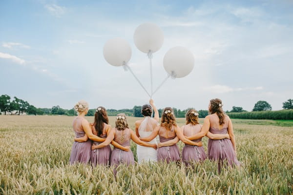 Bride and bridesmaids in field at Sandhole Oak Barn