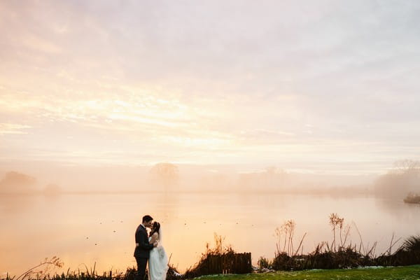 Couple by lake at Sandhole Oak Barn at dusk