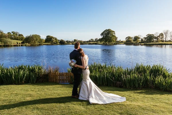 Couple by lake at Sandhole Oak Barn