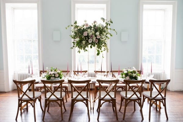 Wooden wedding table and chairs with tall table flowers